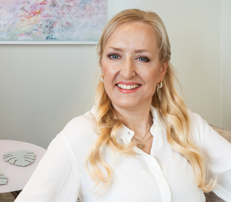 Diana Wünsch, Heilpraktikerin für Psychotherapie, lächelt herzlich in ihrem Therapieraum – einladende Atmosphäre in der Praxis Wünsch Therapie